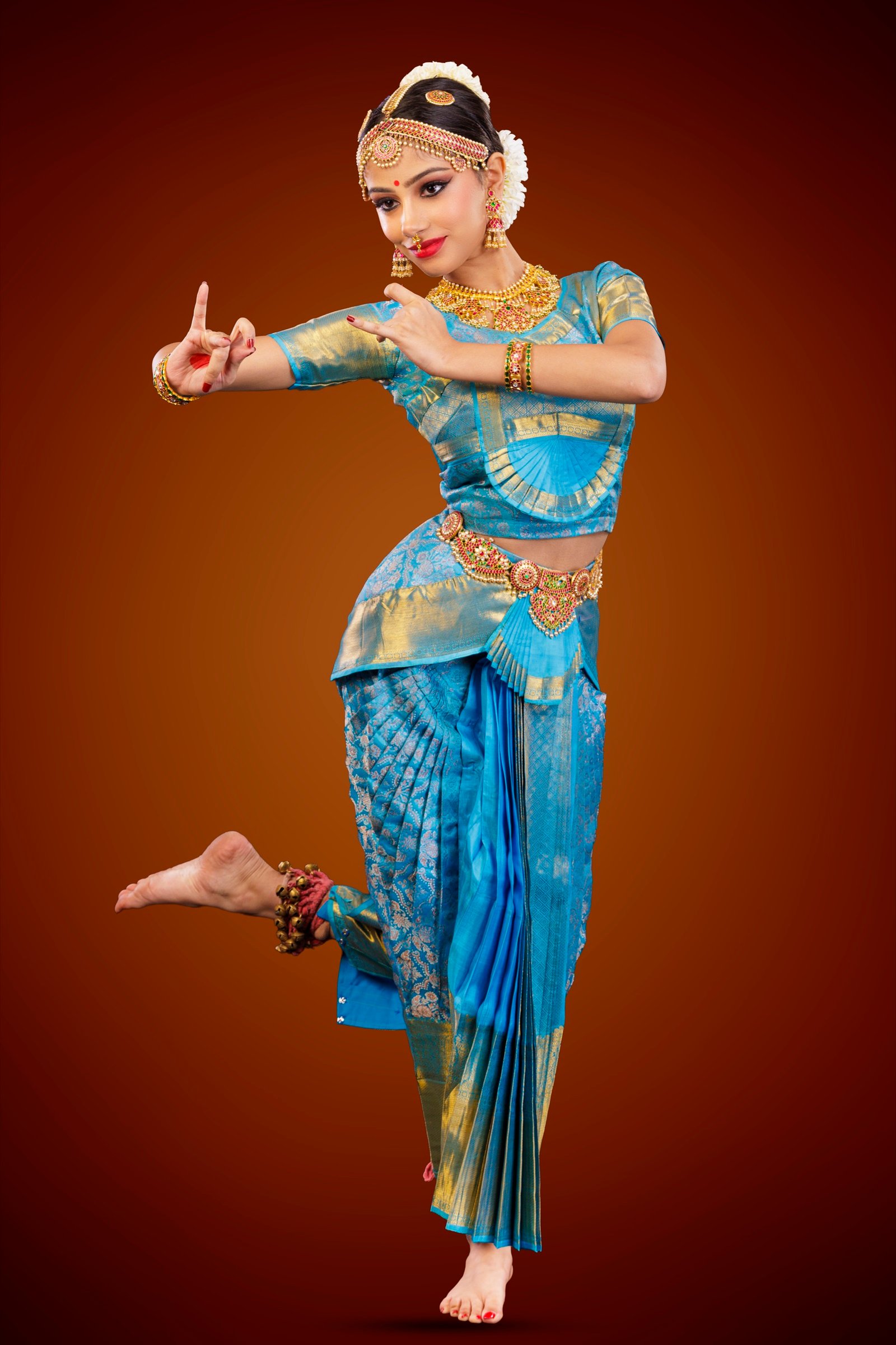 Ilesha in sky-blue silk with one foot raised and fingers in a snapping gesture