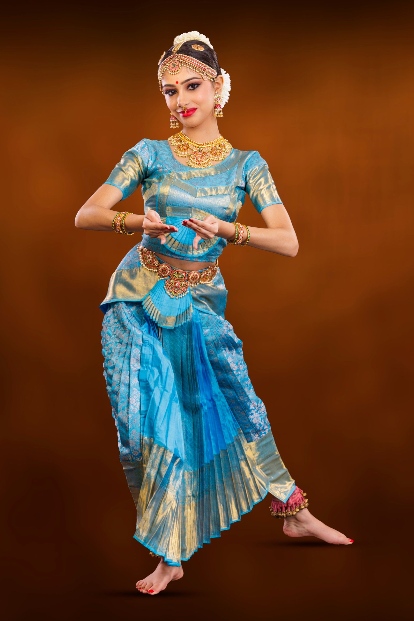 Ilesha with one leg crossed and pointed, hands in delicate mudra