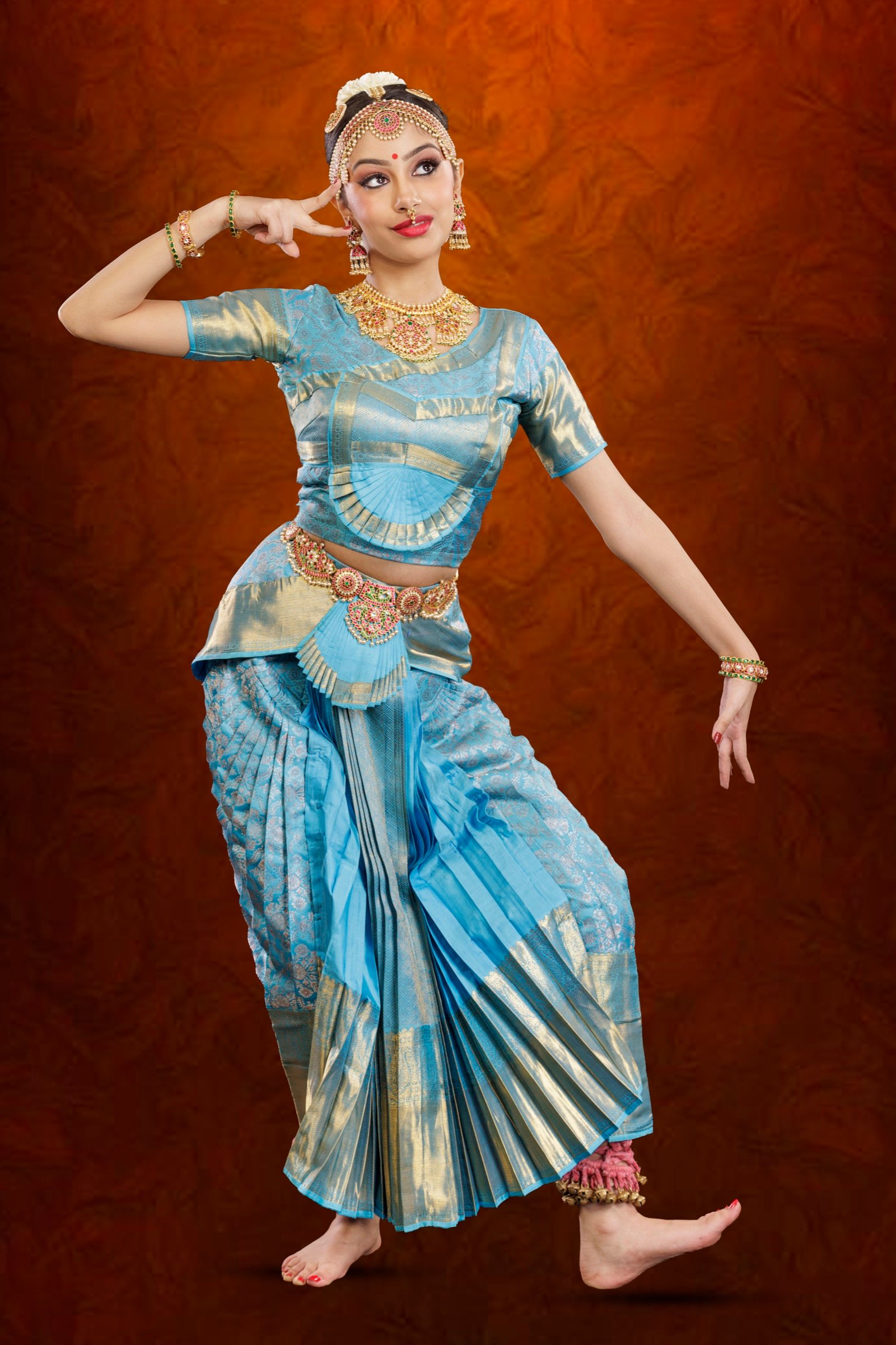 Ilesha with one hand at her head and the other arm extended