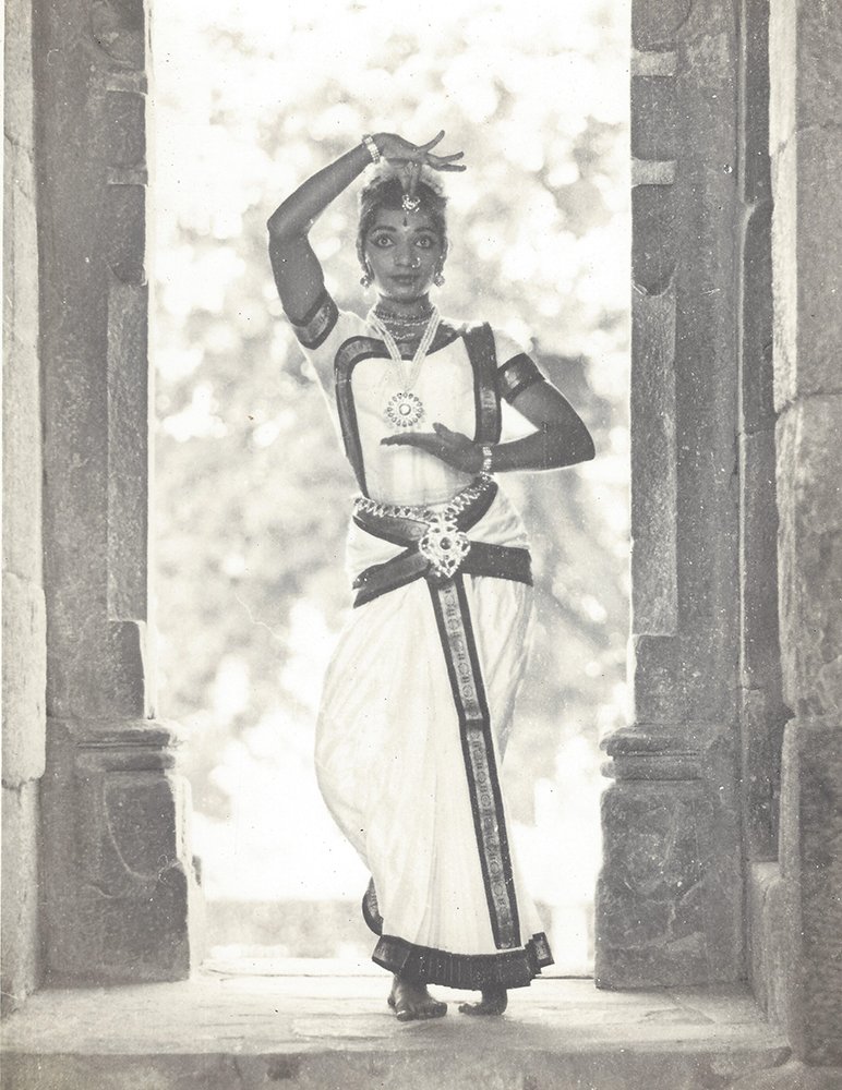 Dr. Radha Reddy in a graceful pose framed by a carved stone doorway